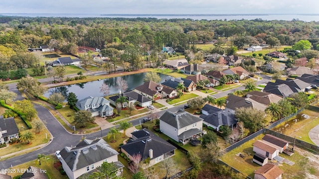 birds eye view of property with a view of trees, a residential view, and a water view