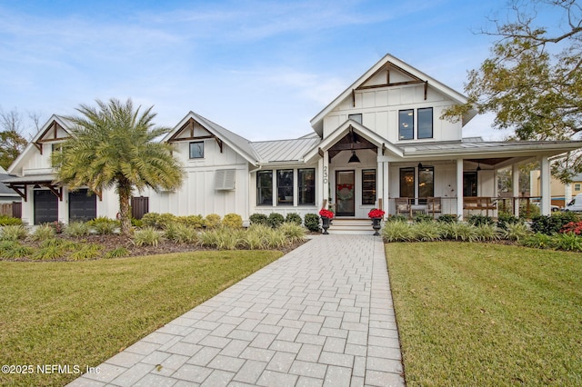 view of front of property with metal roof, covered porch, board and batten siding, a standing seam roof, and a front yard