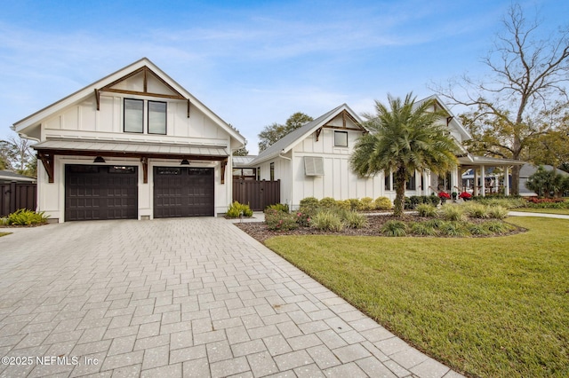 view of front of home with a garage, decorative driveway, board and batten siding, and a front yard