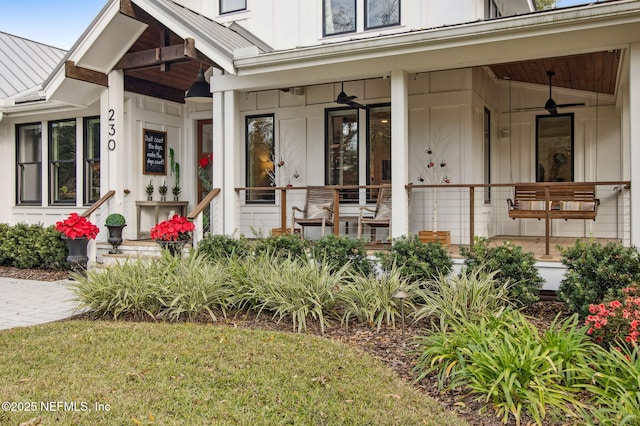 doorway to property with board and batten siding, a standing seam roof, a porch, and metal roof