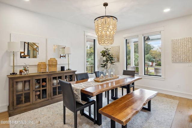 dining area featuring light wood-type flooring, baseboards, a chandelier, and recessed lighting