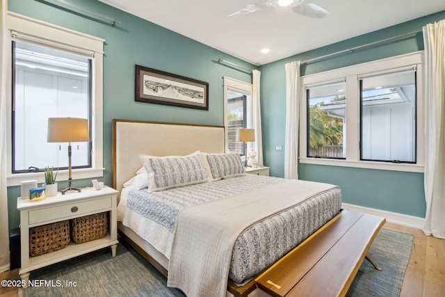 bedroom featuring wood finished floors, a ceiling fan, and baseboards