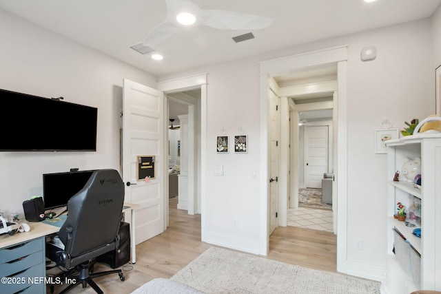 office with baseboards, visible vents, and light wood finished floors