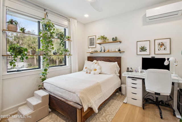 bedroom featuring light wood-type flooring, an AC wall unit, and recessed lighting