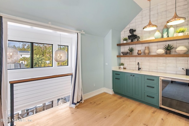 bar with light wood-style flooring, beverage cooler, baseboards, vaulted ceiling, and decorative backsplash