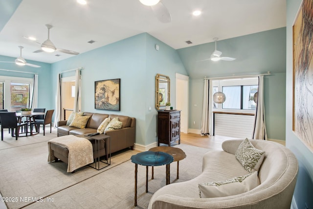 living area with baseboards, visible vents, a ceiling fan, and a healthy amount of sunlight