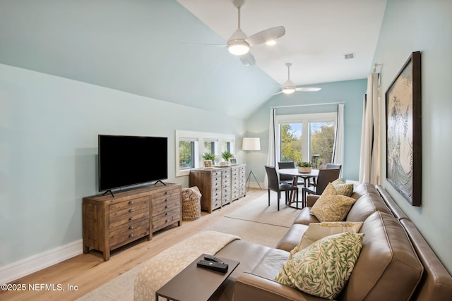 living area with visible vents, a ceiling fan, vaulted ceiling, baseboards, and light wood finished floors