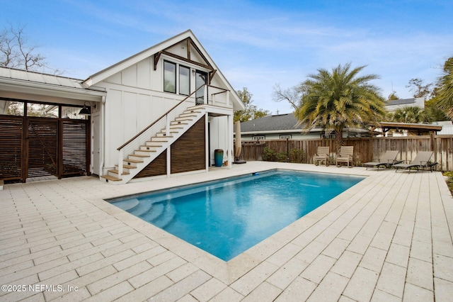 view of pool featuring a fenced in pool, fence, stairway, and a patio