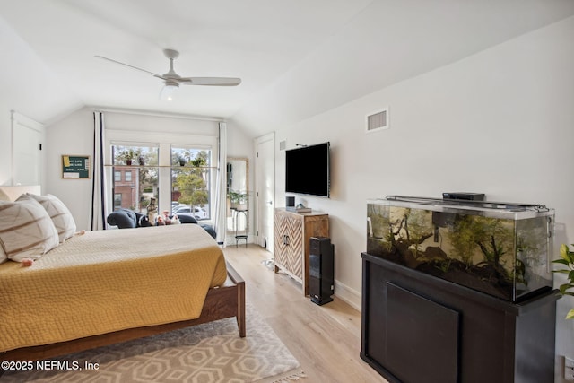 bedroom featuring baseboards, visible vents, a ceiling fan, lofted ceiling, and light wood-type flooring