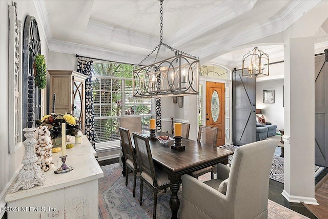 dining space featuring baseboards, arched walkways, ornamental molding, a tray ceiling, and a chandelier