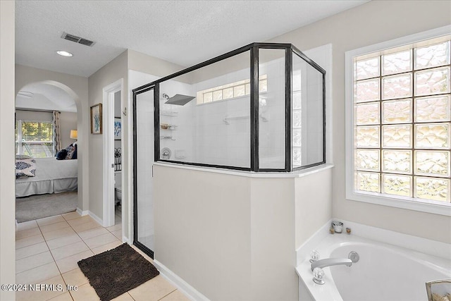 ensuite bathroom with visible vents, a shower stall, ensuite bath, a textured ceiling, and tile patterned flooring