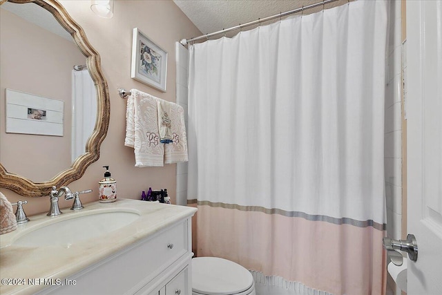 full bathroom featuring toilet, a textured ceiling, and vanity