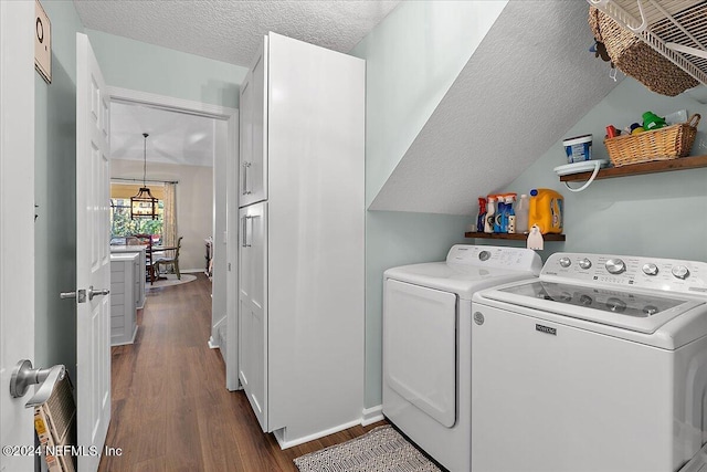 laundry area with dark wood-style floors, baseboards, a textured ceiling, and washing machine and clothes dryer