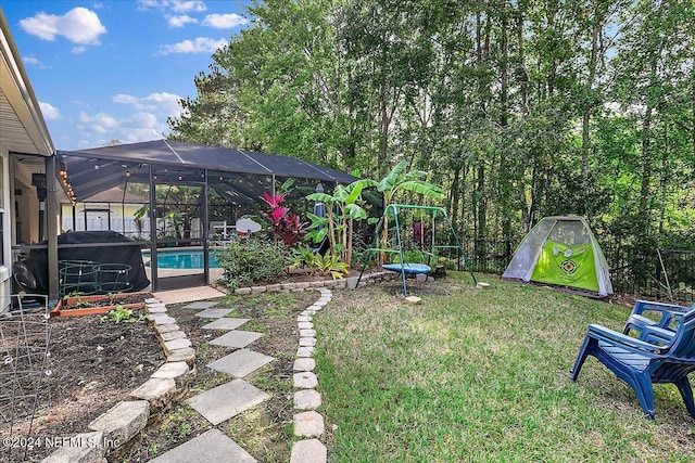 view of yard featuring a lanai, an outdoor pool, and a playground