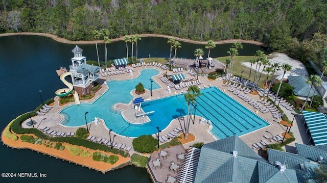 community pool featuring a water view, a water slide, and a patio