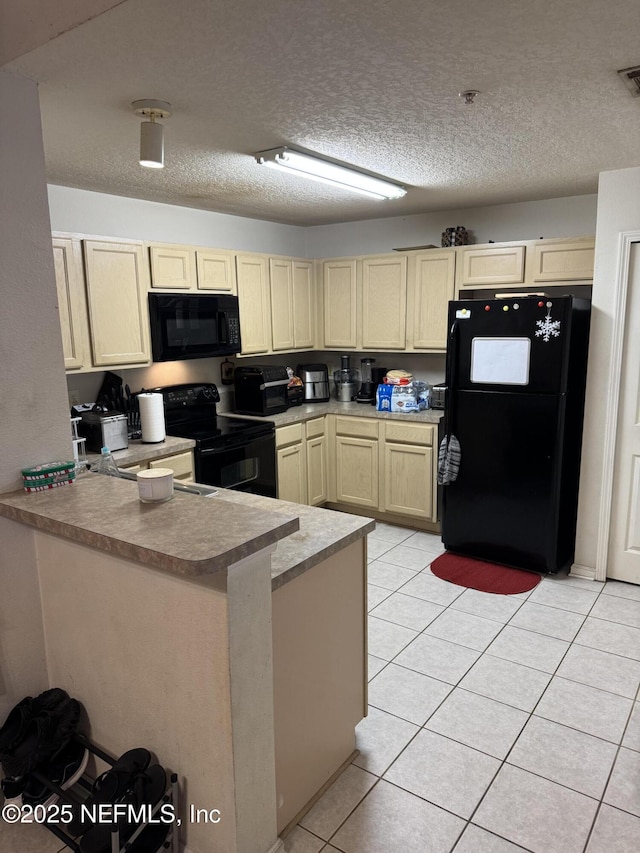 kitchen with a peninsula, black appliances, light tile patterned floors, and a textured ceiling