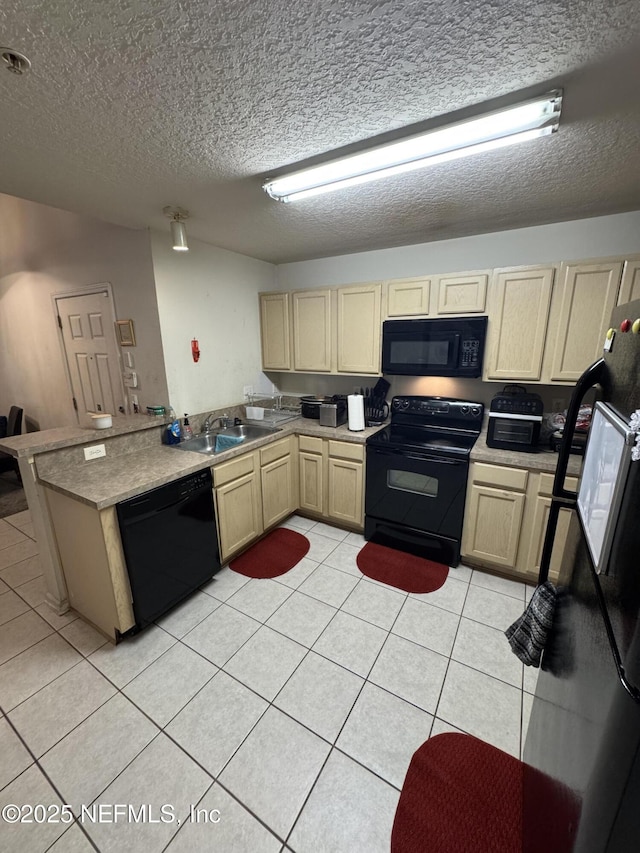 kitchen featuring light tile patterned floors, a sink, a textured ceiling, a peninsula, and black appliances