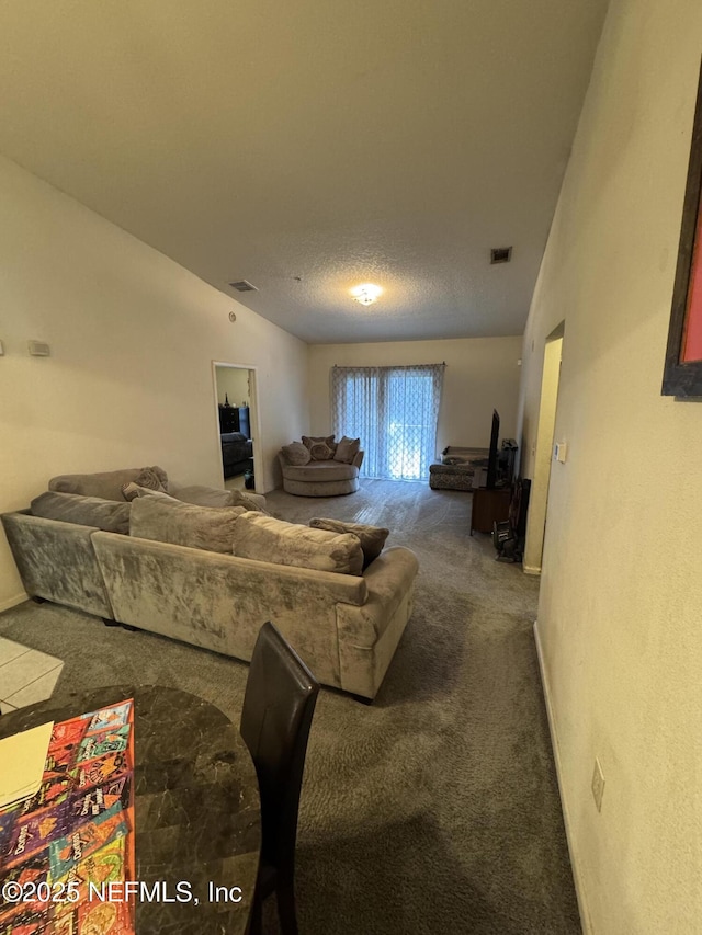 living room featuring lofted ceiling, a textured ceiling, carpet flooring, and visible vents