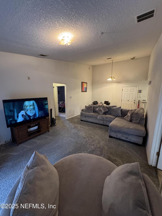 living area with visible vents, a textured ceiling, and carpet flooring