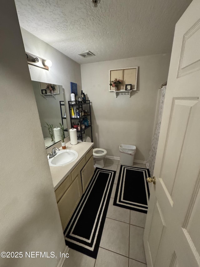 bathroom featuring visible vents, toilet, tile patterned flooring, a textured ceiling, and vanity