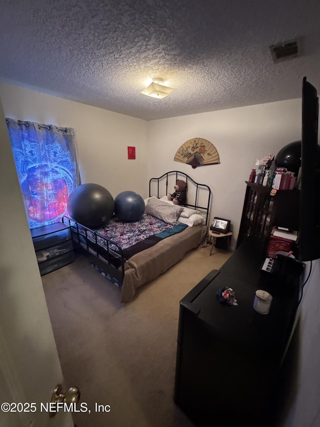 carpeted bedroom with a textured ceiling and visible vents