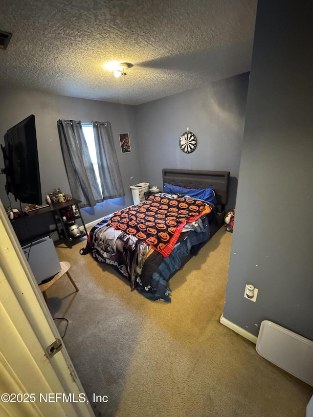 bedroom featuring a textured ceiling and carpet