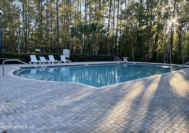 community pool featuring fence and a patio