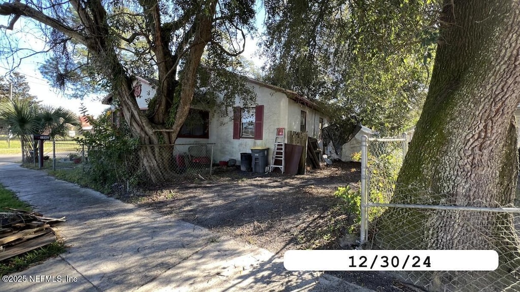 view of property exterior featuring fence and stucco siding