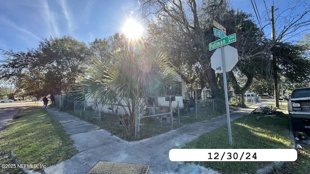 view of side of home featuring fence and a lawn