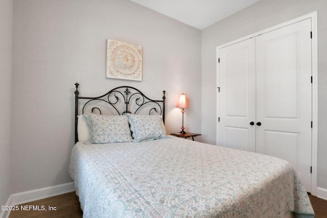 bedroom with a closet, baseboards, and wood finished floors