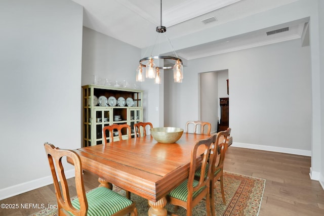 dining space with visible vents, baseboards, and wood finished floors