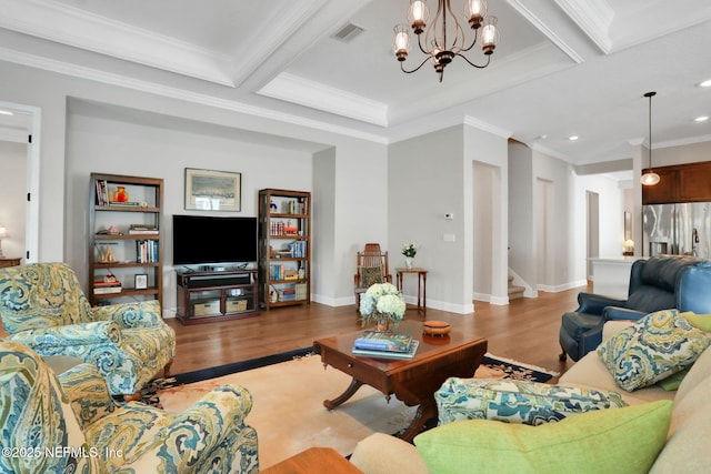 living room with visible vents, wood finished floors, crown molding, and a chandelier