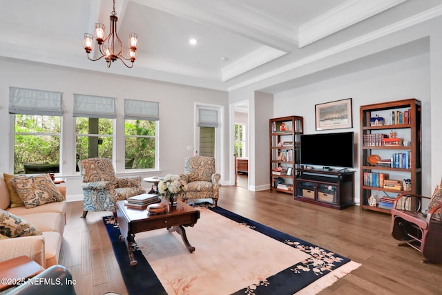 living area featuring wood finished floors, baseboards, an inviting chandelier, recessed lighting, and ornamental molding