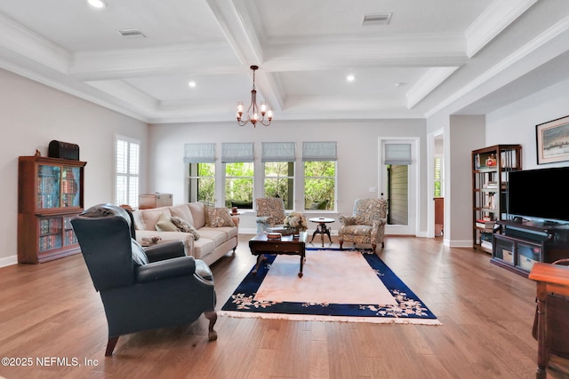 living room with visible vents, a notable chandelier, and wood finished floors