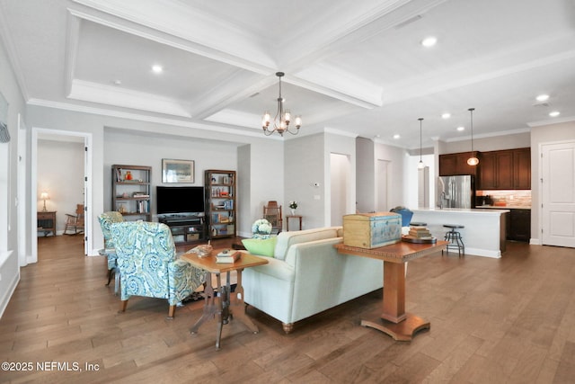 living room featuring an inviting chandelier, beamed ceiling, wood finished floors, and ornamental molding