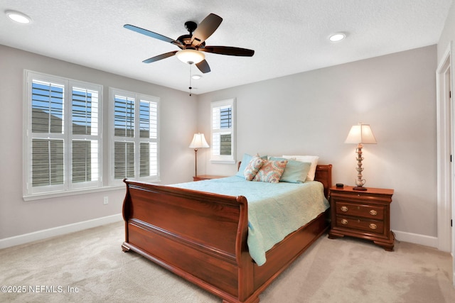 bedroom featuring a textured ceiling, baseboards, and light carpet