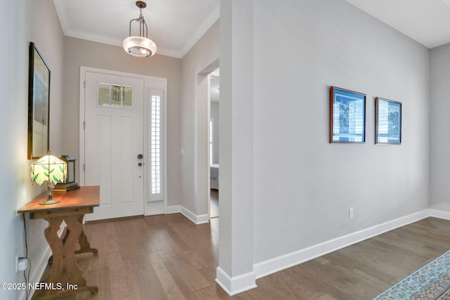 entrance foyer with baseboards, wood finished floors, and ornamental molding