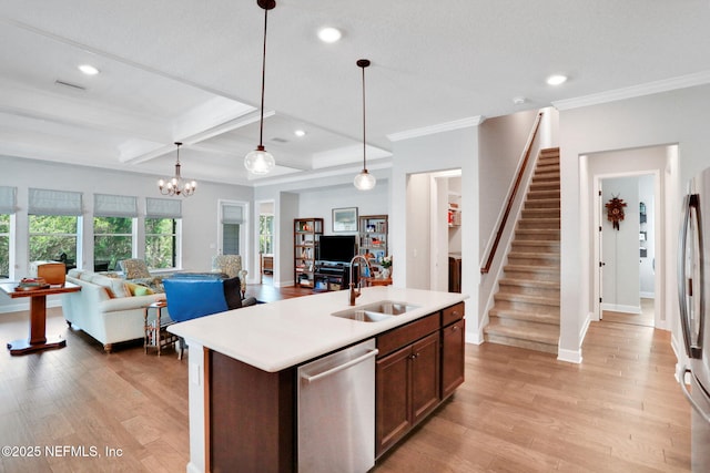 kitchen featuring a sink, light countertops, light wood-style floors, appliances with stainless steel finishes, and open floor plan