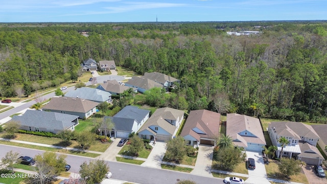 drone / aerial view featuring a forest view and a residential view