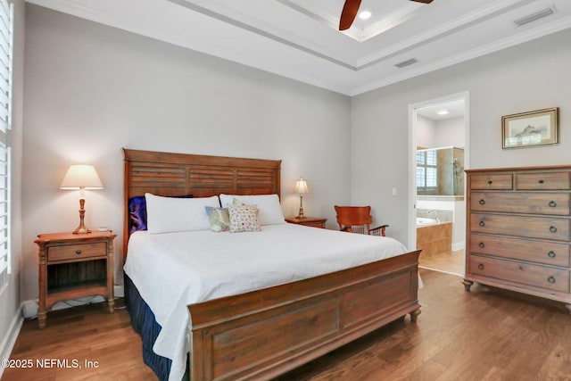 bedroom featuring visible vents, wood finished floors, and ornamental molding