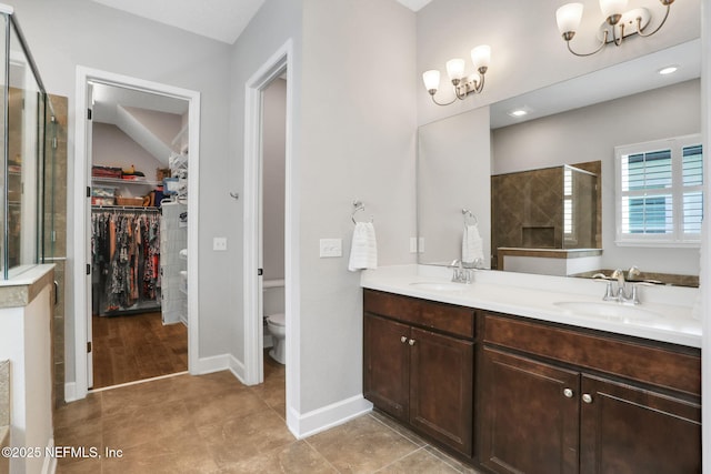 full bathroom with a sink, a shower stall, double vanity, and a chandelier