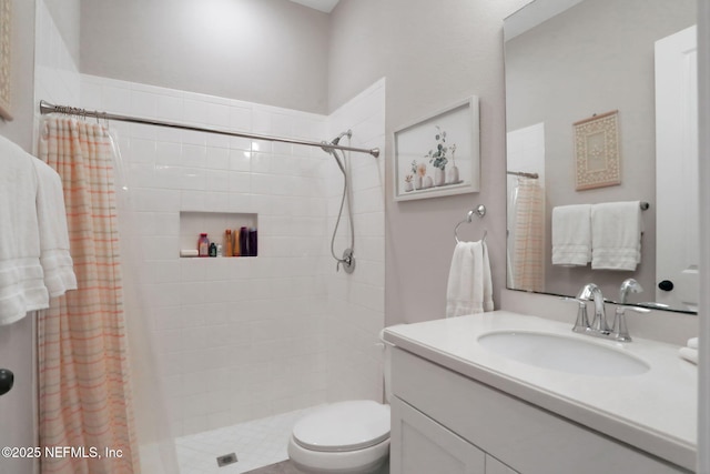 bathroom featuring vanity, toilet, and a tile shower