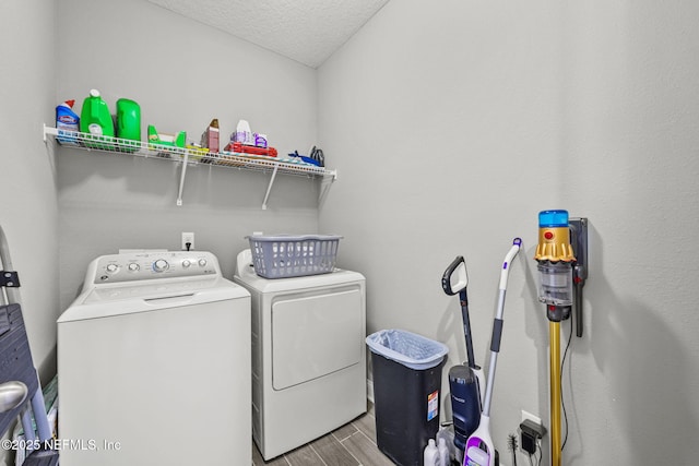 washroom with washing machine and dryer, laundry area, a textured ceiling, and wood tiled floor