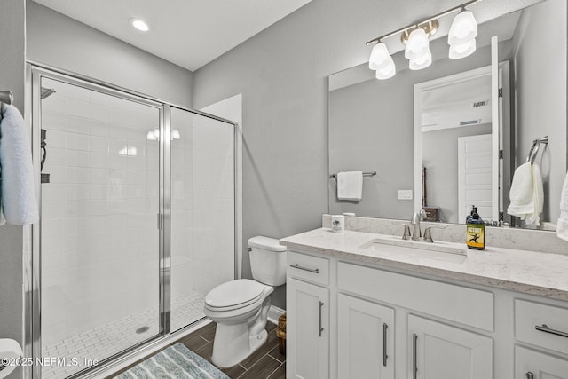 bathroom with a stall shower, vanity, toilet, and wood tiled floor