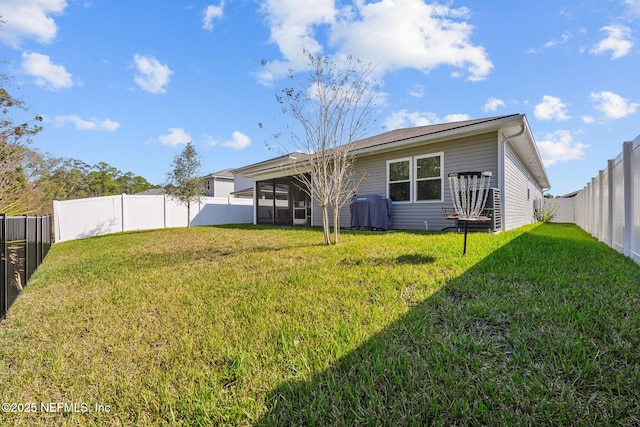 back of house featuring a sunroom, a fenced backyard, and a lawn