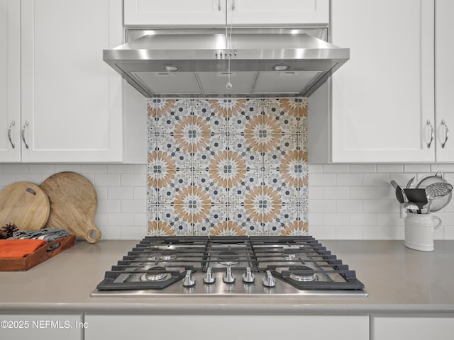 kitchen with stainless steel gas stovetop, white cabinetry, extractor fan, and light countertops