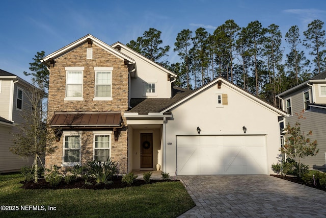 traditional home with metal roof, an attached garage, a standing seam roof, decorative driveway, and stucco siding