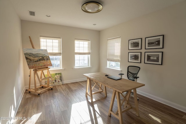 office featuring baseboards, visible vents, and wood finished floors