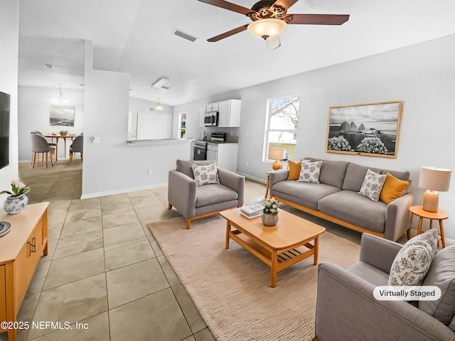 living room with visible vents, a ceiling fan, light tile patterned flooring, vaulted ceiling, and baseboards