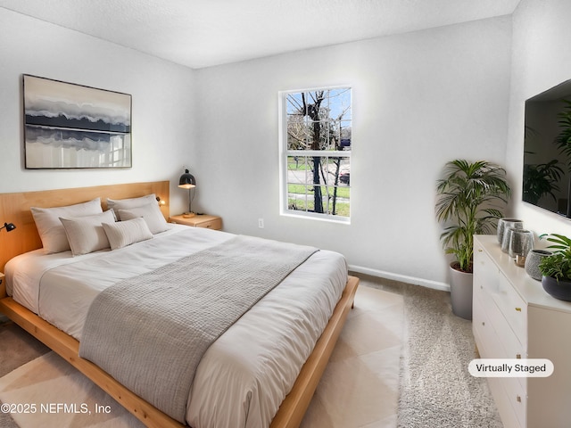 bedroom with light colored carpet and baseboards